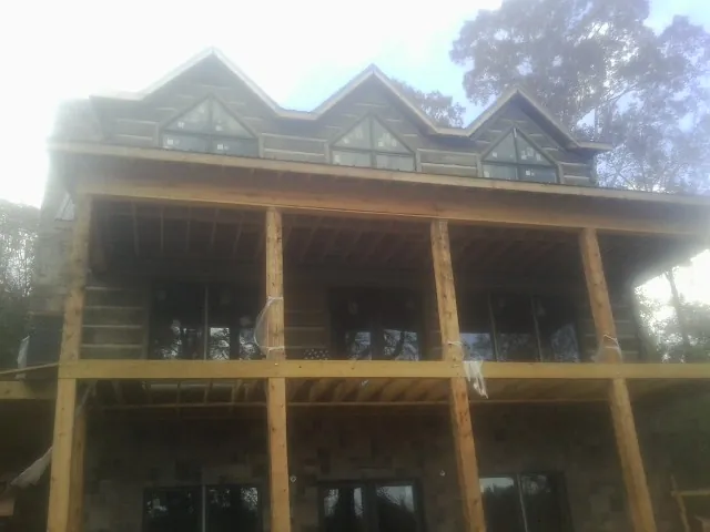 Dormers and porch framing on a large log home under construction — Roof Coating work by our crew in Lake Stevens
